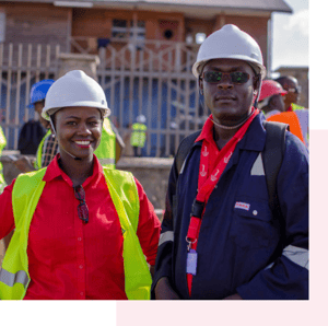 Two South African site workers in hard hats and high-visibility vests